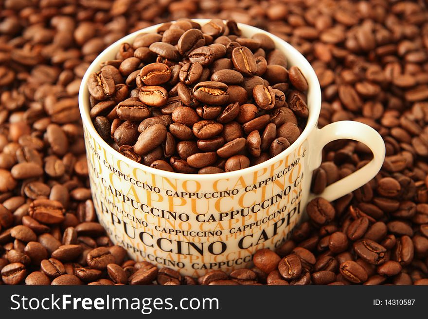Fresh brown coffee beans in a cappuccino cup