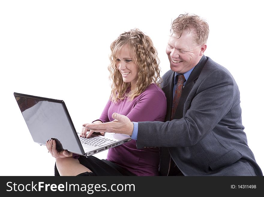 A couple is sitting with a computer and smiling at what they see. A couple is sitting with a computer and smiling at what they see.