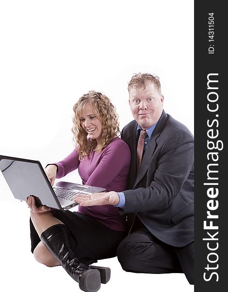 A couple sitting with a computer and happy expressions. A couple sitting with a computer and happy expressions