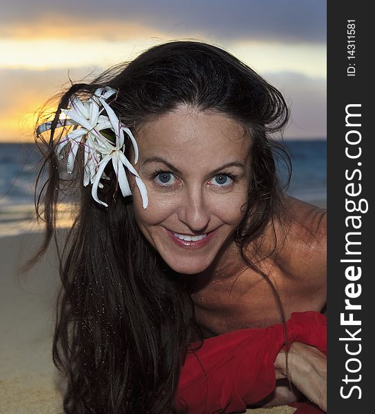 Forty year old woman in red chiffon on the beach in hawaii. Forty year old woman in red chiffon on the beach in hawaii