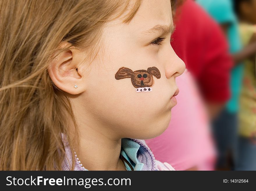 Young girl at a school carnival with her face painted. Young girl at a school carnival with her face painted.