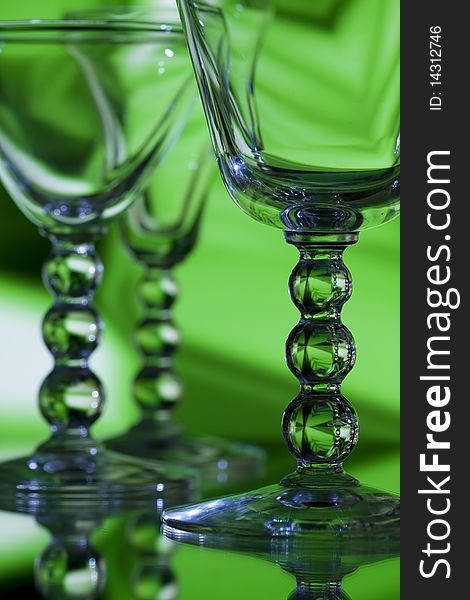 Beautiful wine glasses on abstract green background with detailed focus on front glass. Beautiful wine glasses on abstract green background with detailed focus on front glass