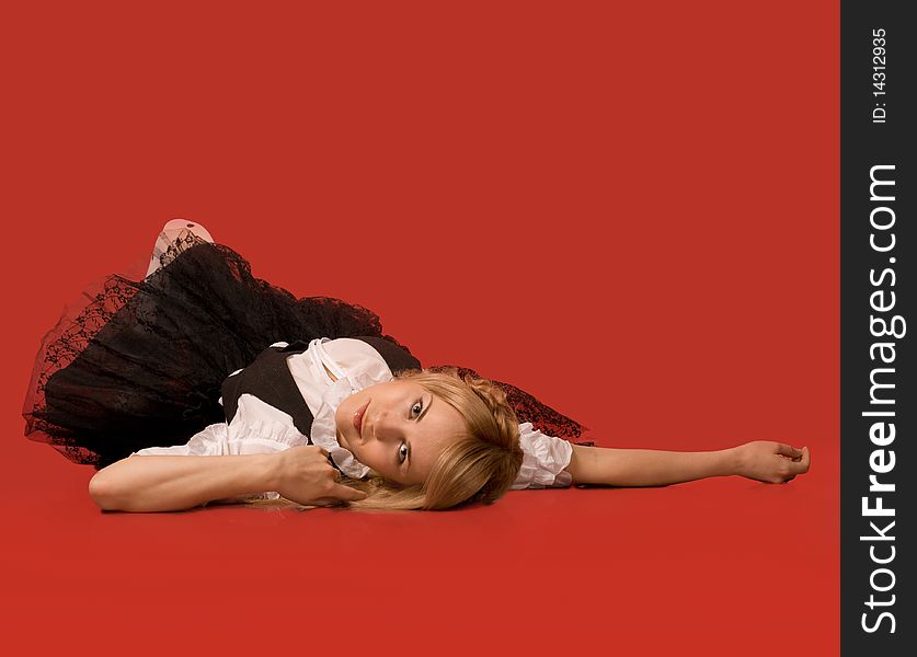 Attractive girl lying on the floor - red background