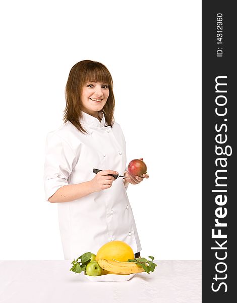 Attractive cook girl holding a knife and a mango - isolated on white