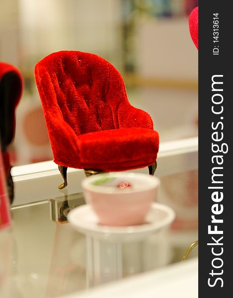 Minature red sofa on glass surface