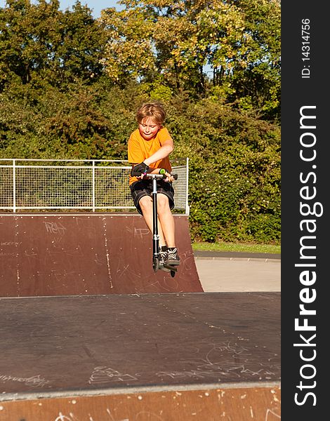 Boy Rides Scooter In A Pipe At A Skate Park