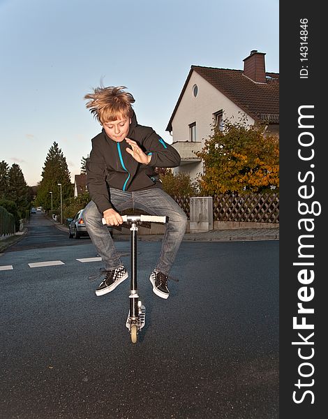 Young Boy Enjoys Riding A Scooter Park