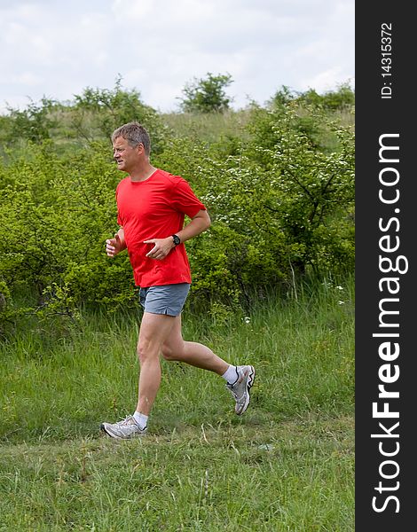 Young man running on a green field. Young man running on a green field