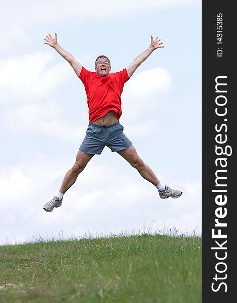 Funny young man high jumping in the field