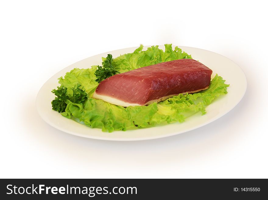 Slice of ham with green salad on white plate. Slice of ham with green salad on white plate
