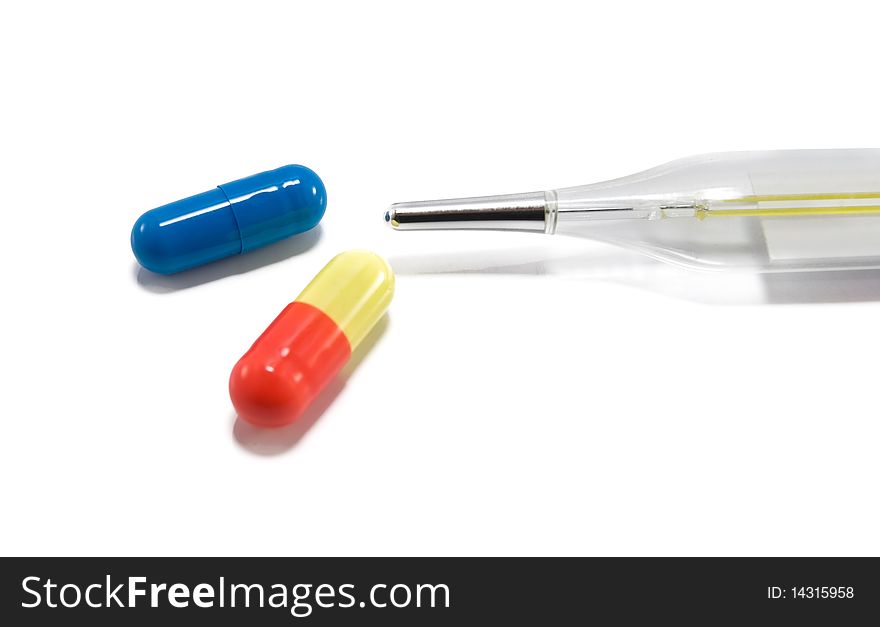 Thermometer and pills is isolated on a white background