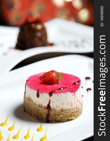 Delicious strawberry chesecake, a real fancy dessert and beautifully presented on a white plate. Delicious strawberry chesecake, a real fancy dessert and beautifully presented on a white plate