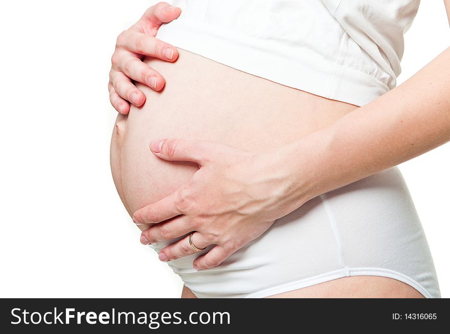 Close-up of a pregnant woman holding her hands on her tummy