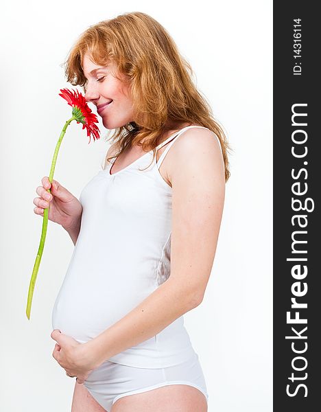 Young pregnant sniffs flower