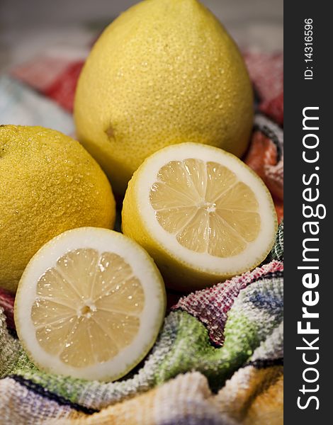 View of some yellow lemons sliced on top of table cloth. View of some yellow lemons sliced on top of table cloth.