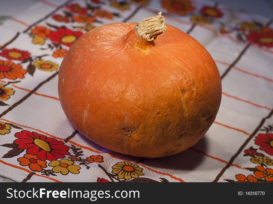 Close view of a orange pumpkin on top of the table.