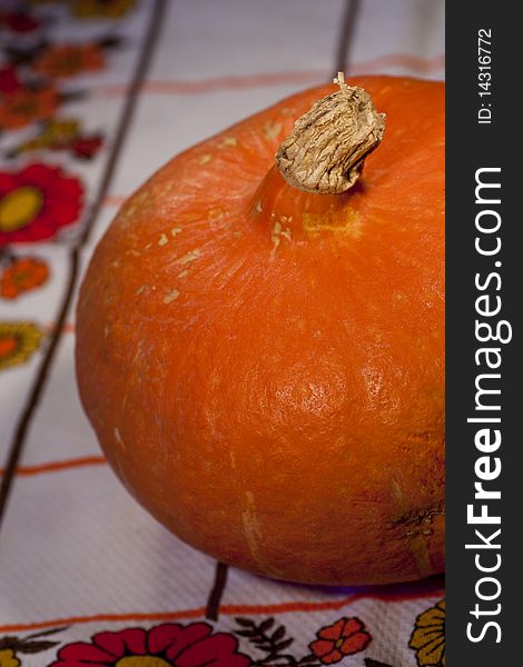 Close view of a orange pumpkin on top of the table.