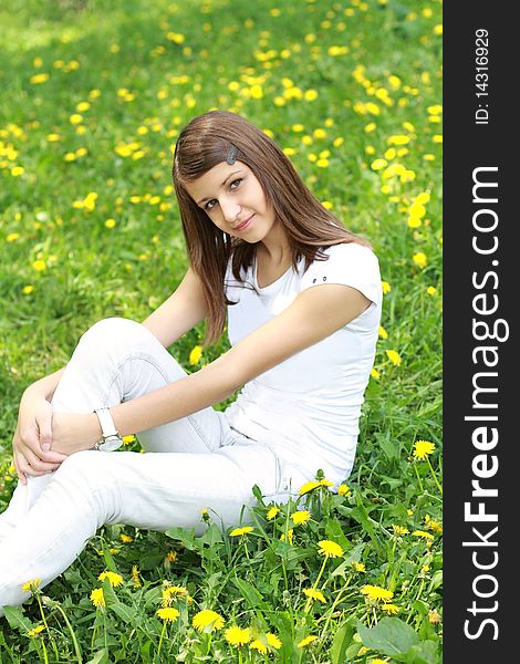 Teenager girl on the glade with dandelions