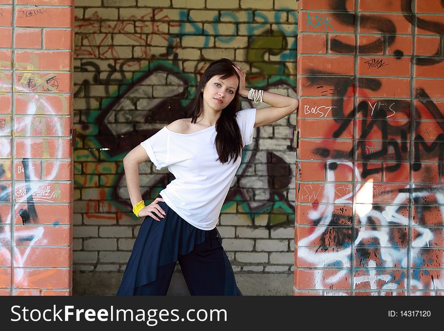 Young  girl near the walls with graffiti