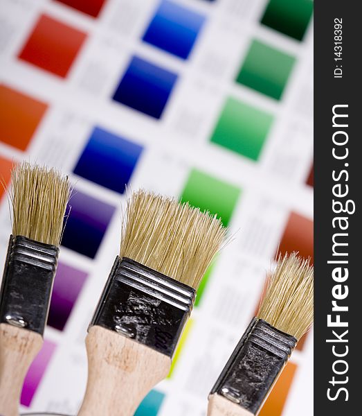 Artistic equipment: paint, brushes and knives on paint background. Artistic equipment: paint, brushes and knives on paint background