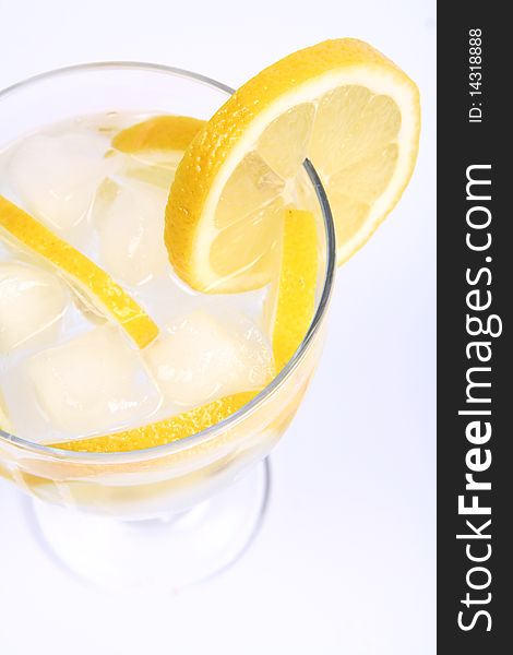 Water with lemon slices and ice in a glass cup on white background. Water with lemon slices and ice in a glass cup on white background