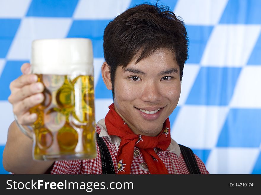 Happy Asian man holds Oktoberfest beer stein