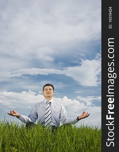 Businessman sits quietly in the lotus position on grass. Businessman sits quietly in the lotus position on grass