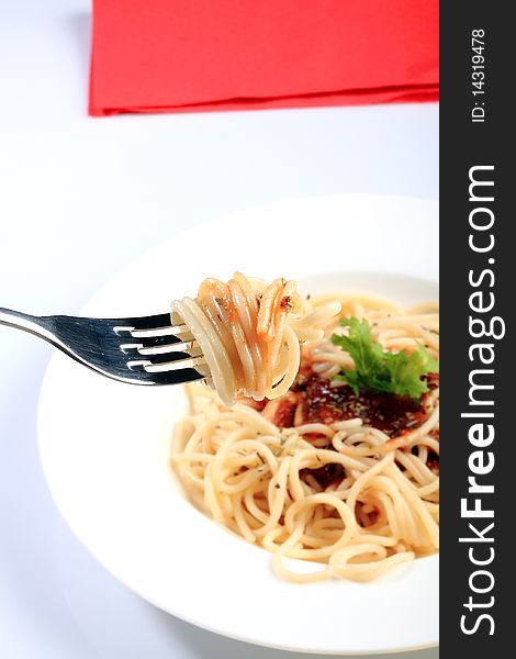 Spaghetti with tomato and basil on fork