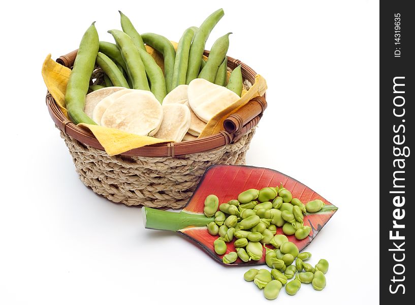 Basket with beans and bread on white background