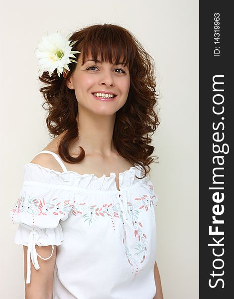 A smiling woman with a flower in her hair isolated