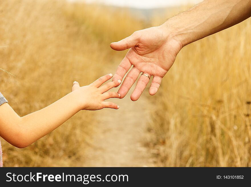 A beautiful hands of a happy child and parent in the nature park