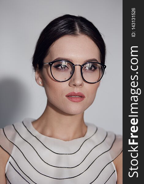 Beauty portrait of a young elegant woman in eyeglass, isolated on a white background. Vertical view.