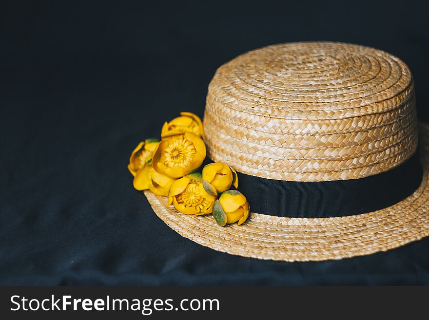 Bouquet Of Yellow Waterlily Flower With Green Leaf. Freshly Ripped Up. In A Straw Hat. Close Up On Black Background Of Fabric.