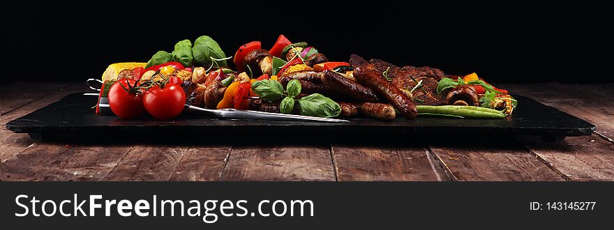 Assorted delicious grilled meat and skewer with vegetable on rustic table