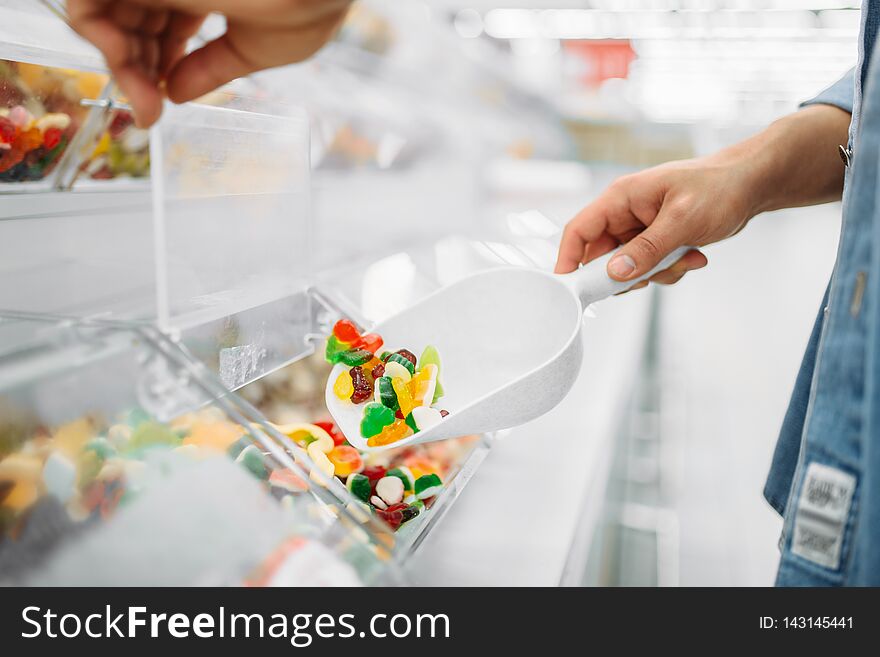 Male person picks up package of sweet chewy candy