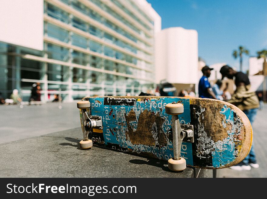 Close up of used skateboard in urban environment during sunny day with clear blue sky on wall