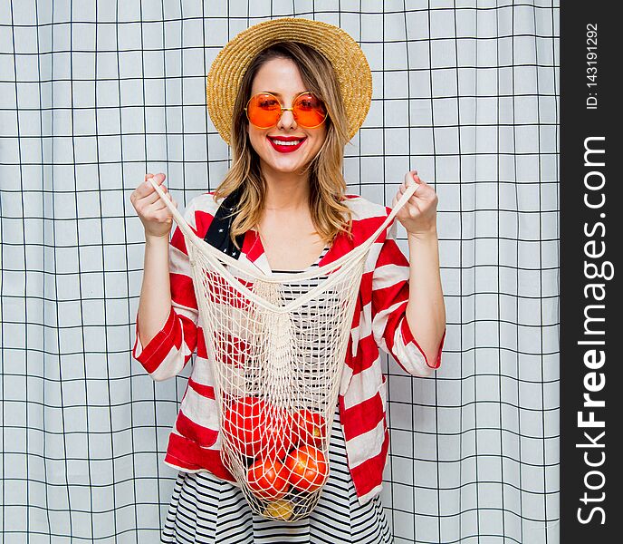 Smiling Woman In Hat And Striped Jacket With Net Bag