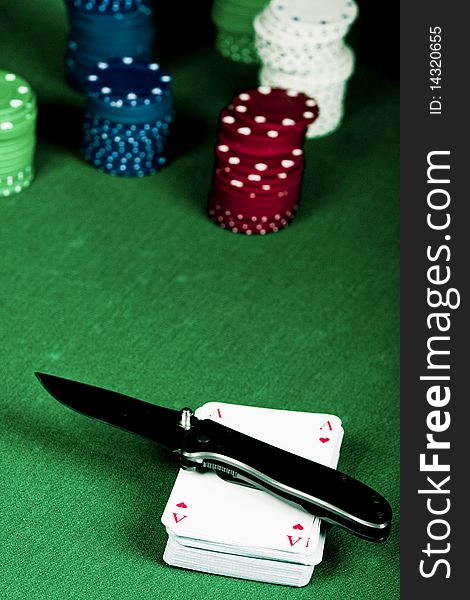 Casino gambling chips, cards and knife  on green table. Casino gambling chips, cards and knife  on green table