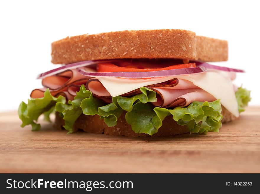 Delicious ham sandwich with whole wheat bread on cutting board. Delicious ham sandwich with whole wheat bread on cutting board