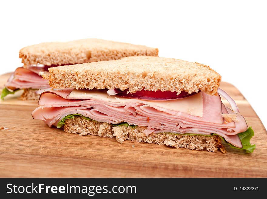Delicious ham sandwich with whole wheat bread cut in half. Delicious ham sandwich with whole wheat bread cut in half