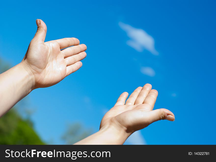 Two hands against the blue sky