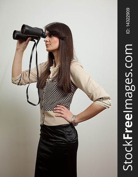 Young business woman holding and looking through binoculars. Isolated on white. Young business woman holding and looking through binoculars. Isolated on white