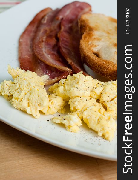 Bacon, Scrumbled Eggs and Toast on white plate