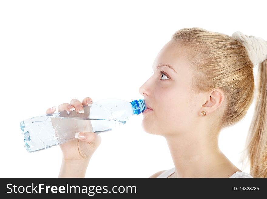 Young blonde is drinking water isolated on white. Focus on girl`s eyes.