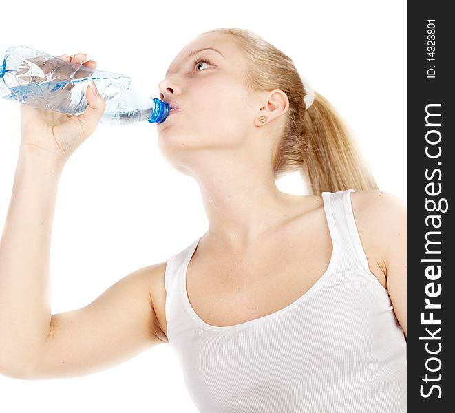 Young blonde is drinking water isolated on white. Focus on hand with bottle.