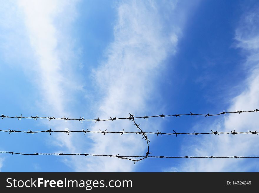 Barbed wire on the blue sky background