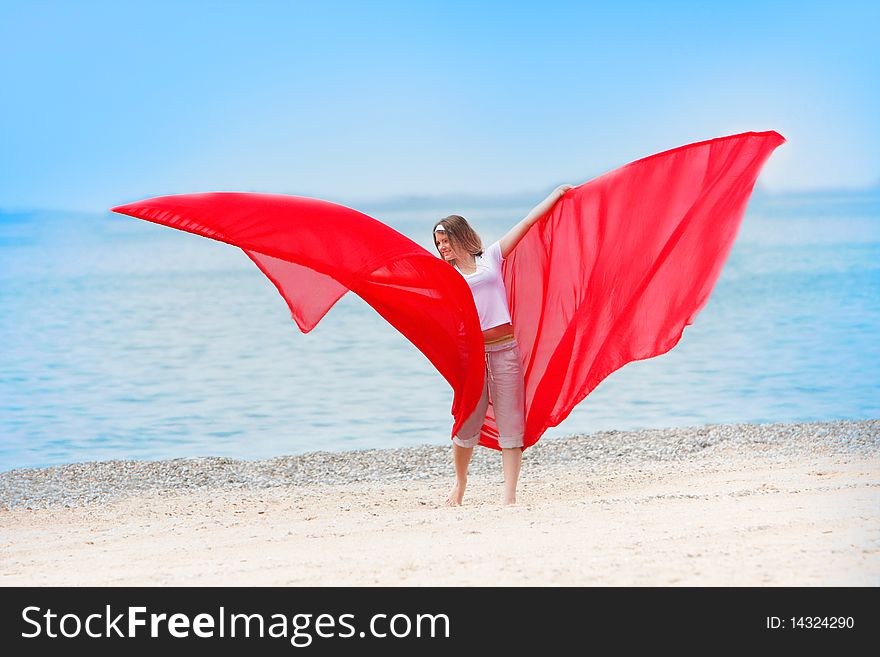 Young happy girl with red wings on sea background