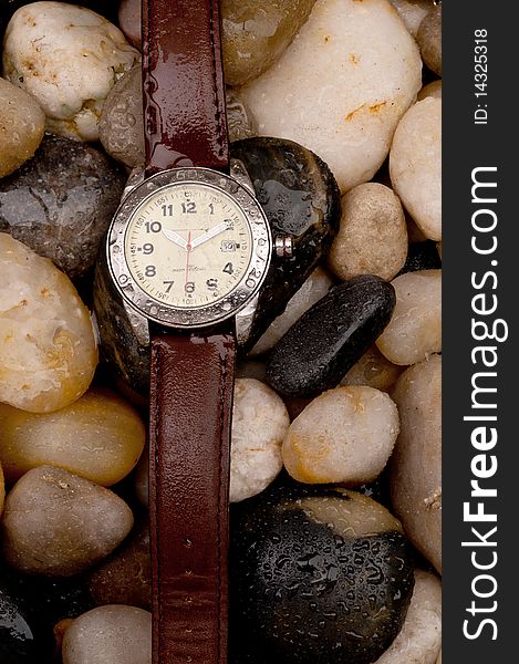 Diving wristwatch on wet pebbles