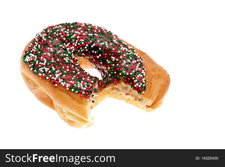 A single donut with chocolate icing and sprinkles with a bite taken out of it on white