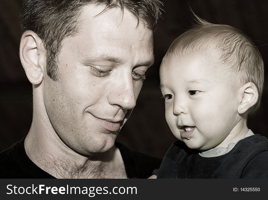 Multiracial Asian American child with his proud dad in sepia tone. You can just see the love between them. Multiracial Asian American child with his proud dad in sepia tone. You can just see the love between them.